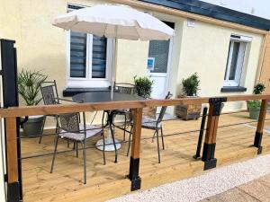 un tavolo e sedie su una terrazza con ombrellone di Eco-Appart'hôtel Rouen -- JDP a Rouen
