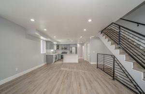 an empty living room with a staircase and a kitchen at Green HomeStay address changed in Los Angeles