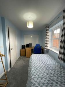 a bedroom with a bed and a desk and a window at Tootle Drive in Longridge