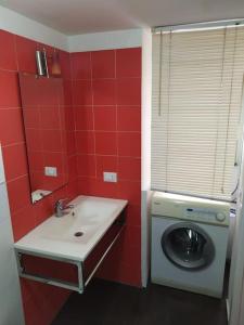 a red bathroom with a washing machine and a sink at Andy's Home in Catania