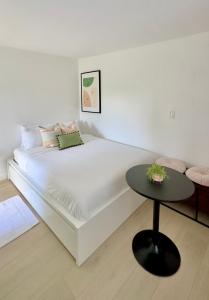 Una cama blanca con una mesa negra en una habitación en Miami CUTE en Miami
