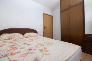 Un dormitorio con una cama con una colcha floral. en Apartman Ana, en Kupres