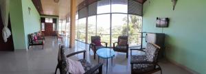 a room with chairs and a table and a large window at Suisse View Residence Kandy in Kandy