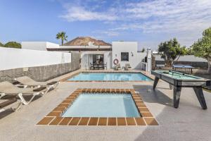 a villa with a pool and a table and chairs at Villa Bezanilla - VipVipVillas in Playa Blanca