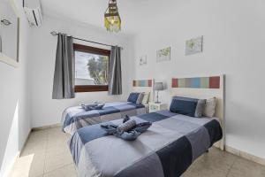 two beds in a room with a window at Villa Bezanilla - VipVipVillas in Playa Blanca +20 photos