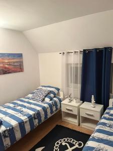 a bedroom with two beds and a blue curtain at Apartament Ustronie Leśne in Międzyzdroje