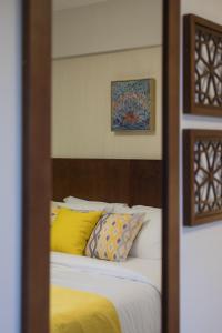 riflesso di un letto con cuscini gialli in uno specchio di Lemon Spaces KHAN- Zamalek a Il Cairo