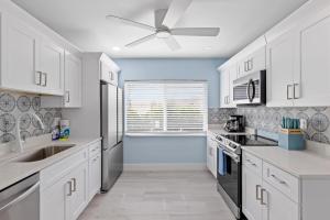 a kitchen with white cabinets and a ceiling fan at Palm Retreat - Large Cottage on Sanibel Island with Bikes in Sanibel