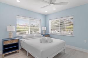 a bedroom with two beds and a ceiling fan at Palm Retreat - Large Cottage on Sanibel Island with Bikes in Sanibel