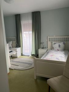 a bedroom with a bed and a large window at Gästehaus Elisabeth in Weisenheim am Sand