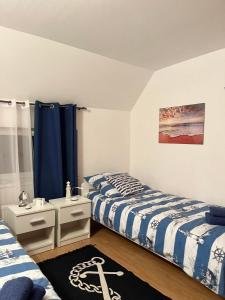 two beds in a room with blue curtains at Apartament Ustronie Leśne in Międzyzdroje