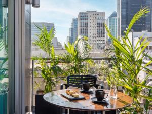 a table on a balcony with a view of a city at HTL Urbano in Buenos Aires