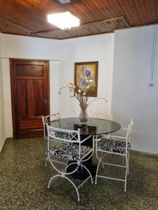 een tafel met twee stoelen en een vaas met bloemen erop bij Acutí Departamento in Puerto Iguazú +8 foto's