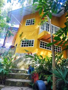 a yellow house with stairs in front of it at Mí tesorito in Melgar