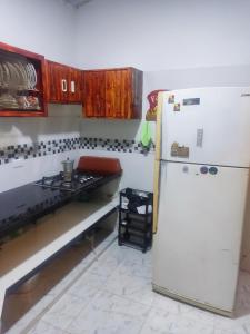 a kitchen with a white refrigerator and a stove at Mí tesorito in Melgar