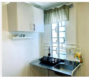 eine kleine Küche mit einem Waschbecken und einem Fenster in der Unterkunft JC. Caribe Aparta Hotel… in Ensanche Vista Alegre