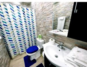 La salle de bains est pourvue de toilettes blanches et d'un lavabo. dans l'établissement JC. Caribe Aparta Hotel…, à Ensanche Vista Alegre