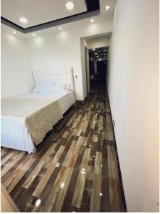 um quarto com uma cama e piso em madeira em JC. Caribe Aparta Hotel… em Ensanche Vista Alegre