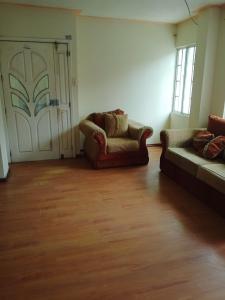 sala de estar con 2 sofás y puerta corredera en Syj en Loja