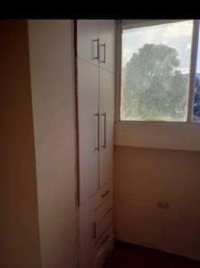 um quarto com uma janela e um armário branco em Syj em Loja