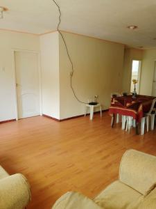 an empty living room with a table and chairs at Syj in Loja