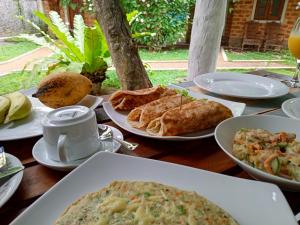 a wooden table with plates of food on it at Sky View Cabin Unawatuna in Unawatuna