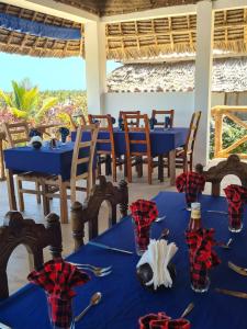 uma sala de jantar com mesas azuis e cadeiras com vista em Blue Moon Villa em Pwani Mchangani Mdogo