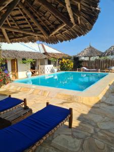 una piscina con 2 tumbonas en un complejo en Blue Moon Villa, en Pwani Mchangani Mdogo