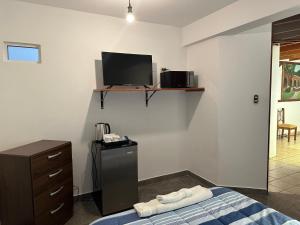1 dormitorio con 1 cama y TV en la pared en Habitacion doble huaca Miraflores, en Lima