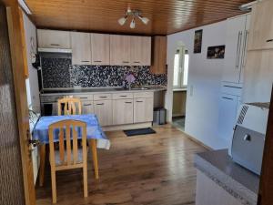 a kitchen with a table and chairs and a refrigerator at Ferienwohnung Gabi in Eigeltingen
