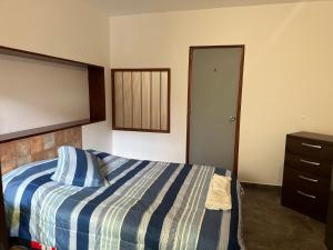 1 dormitorio con 1 cama con manta azul y blanca en Habitacion doble huaca Miraflores, en Lima