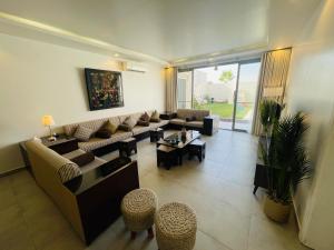 a living room with a couch and tables and chairs at شالية راقي بمسبح وجلسات خارجية in ‘Ilb