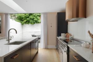 une cuisine avec un évier et une grande fenêtre dans l'établissement Stylish home in the perfect location, à Londres