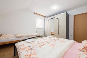 a bedroom with two beds and a large bed with flowers at Apartman BARIŠIĆ 2 in Kupres