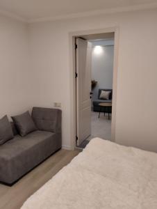 sala de estar con sofá y puerta corredera en Central apartment of Tbilisi, en Tiflis