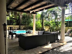 a patio with a table and chairs and a pool at Typical villa , swimming pool, 300 Meters to Langosta Tamarindo beaches in Tamarindo