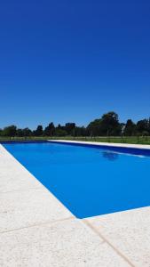 a swimming pool with blue water on a beach at La Quinta de LOS ABU in Ramallo
