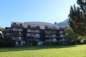 un gran edificio con un campo de césped delante de él en LA Source Blanche, en Saint-Jean