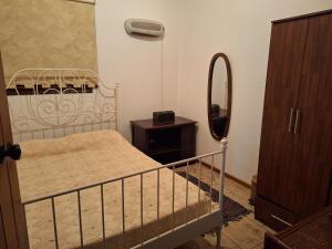 Dormitorio pequeño con cama y espejo en Koukaki, en Kouka