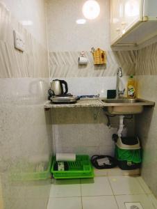 a small kitchen with a sink and a counter at King Bed "STUDIO ROOM"-Khalidiya Abudhabi in Abu Dhabi