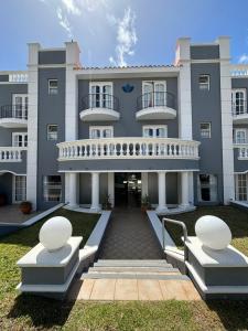 um grande edifício com dois bancos brancos em frente em Bagu Villa de Mar em Punta del Este