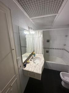 y baño con lavabo, espejo y bañera. en CASA BOMBAL en Mendoza