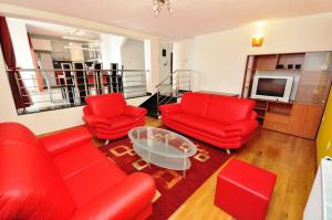 a living room with red furniture and a television at Apartment Luxury Cream in Kaštela
