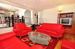 ein Wohnzimmer mit zwei roten Stühlen und einem Tisch in der Unterkunft Apartment Luxury Cream in Kaštela