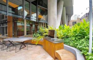 a patio with a table and a tv on a building at Stylish 1BR Entire CBD Apt 5 Minutes Train Station in Sydney