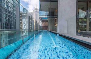 a swimming pool in a building with blue water at Stylish 1BR Entire CBD Apt 5 Minutes Train Station in Sydney