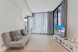 a living room with a couch and a flat screen tv at Stylish 1BR Entire CBD Apt 5 Minutes Train Station in Sydney