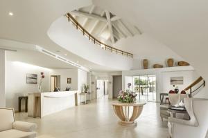 a living room with a staircase and a table at Is Arenas Resort in Narbolia