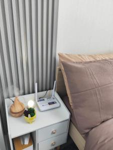 a bed with a table with a laptop on a night stand at Azure North Staycation by 7TwentySix CRIB in San Fernando