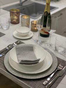 einen Tisch mit Tellern und Gläsern sowie eine Flasche Wein in der Unterkunft 6 AL TOP in Rom